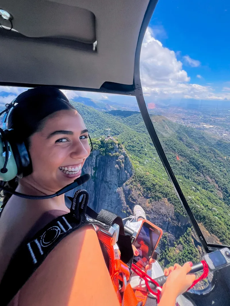 Passenger taking a doors-off shoe selfie on a helicopter ride in Rio de Janeiro, Brazil