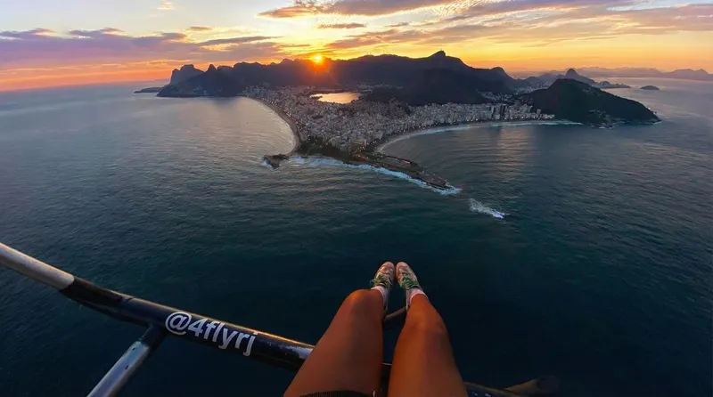 Doors-off helicopter with feet dangling above Rio on a helicopter ride in Rio de Janeiro, Brazil